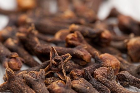 A shallow focus shot of clove spice on a white wooden surface